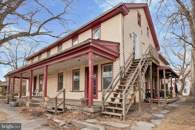 view of front of home with stairway and a porch