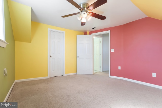 unfurnished bedroom with a ceiling fan, lofted ceiling, light colored carpet, and baseboards