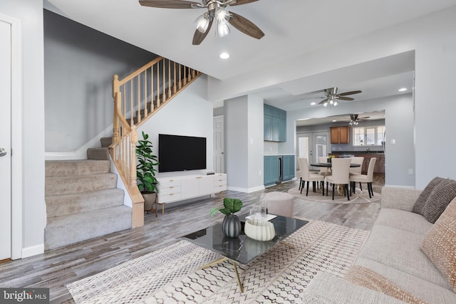 living area with recessed lighting, stairway, baseboards, and wood finished floors