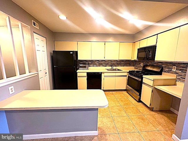 kitchen with tasteful backsplash, light countertops, visible vents, a sink, and black appliances