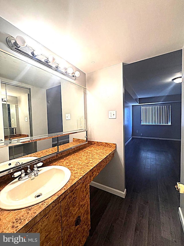 bathroom featuring wood finished floors, vanity, and baseboards