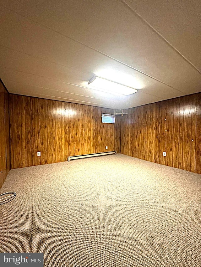 finished basement with baseboard heating, carpet, and wooden walls