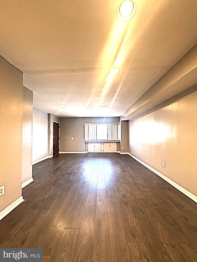 empty room featuring dark wood finished floors and baseboards