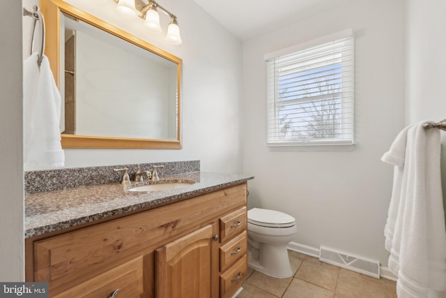 bathroom featuring tile patterned flooring, toilet, vanity, visible vents, and baseboards