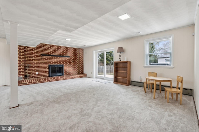 living area featuring a fireplace, baseboard heating, and carpet flooring