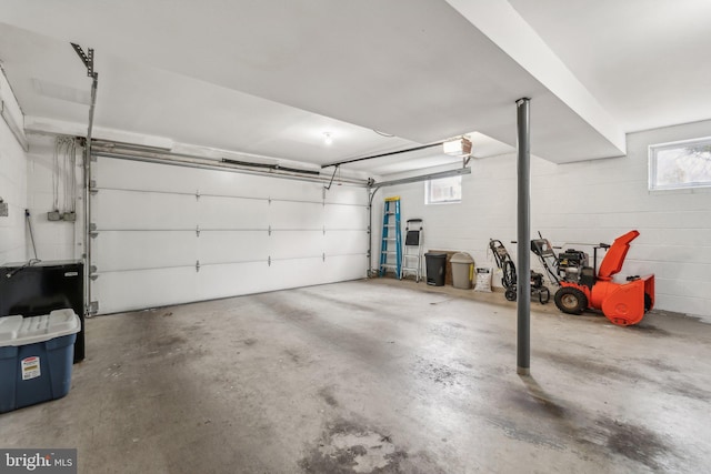 garage with concrete block wall and a garage door opener