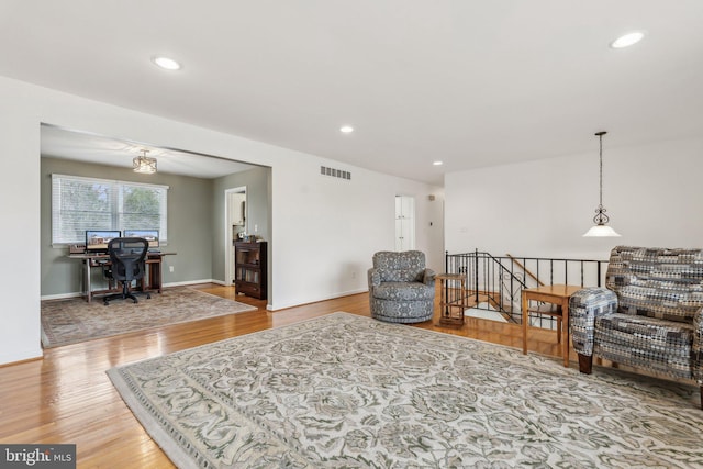 living area featuring baseboards, wood finished floors, visible vents, and recessed lighting