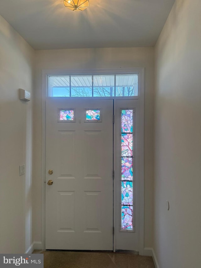 foyer entrance featuring baseboards and plenty of natural light