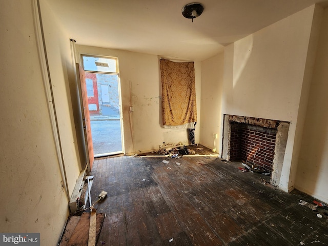 unfurnished living room with dark wood-style floors and a fireplace