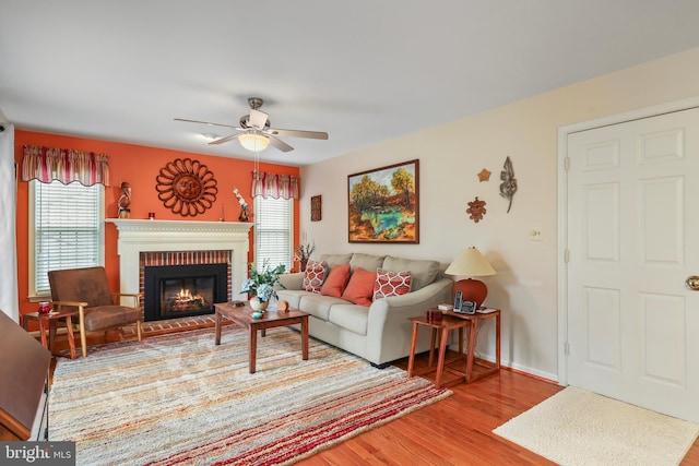 living room with ceiling fan, a healthy amount of sunlight, a fireplace, and wood finished floors