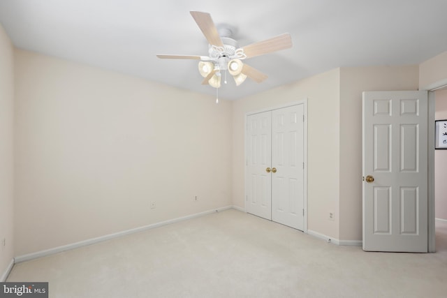 unfurnished bedroom featuring carpet, baseboards, ceiling fan, and a closet