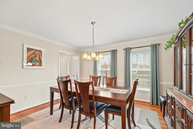 dining space with a chandelier, crown molding, baseboards, and light wood-style floors