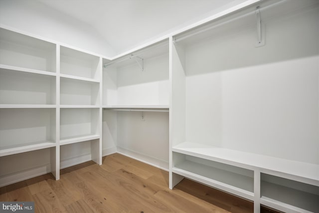 spacious closet featuring vaulted ceiling and wood finished floors