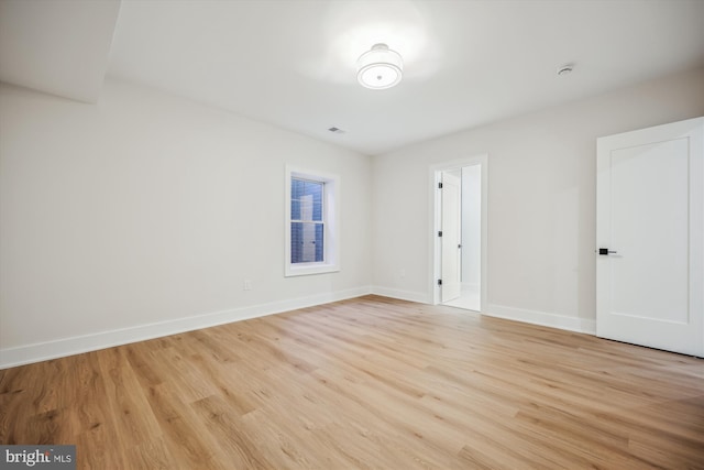 empty room with light wood-style flooring and baseboards