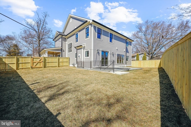 back of house featuring a patio area, a lawn, and a fenced backyard