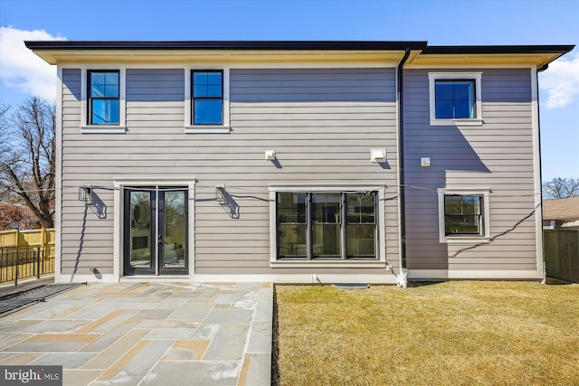 rear view of house with a yard, a patio, and fence