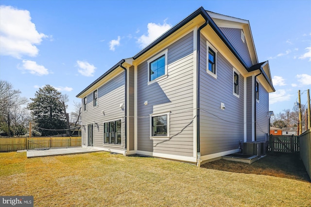 back of house featuring central AC unit, a yard, a fenced backyard, and a patio area