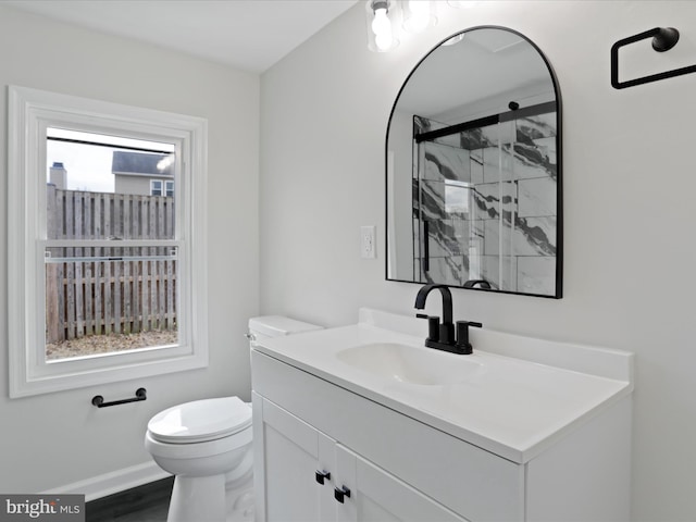 full bath featuring toilet, a marble finish shower, vanity, and a wealth of natural light