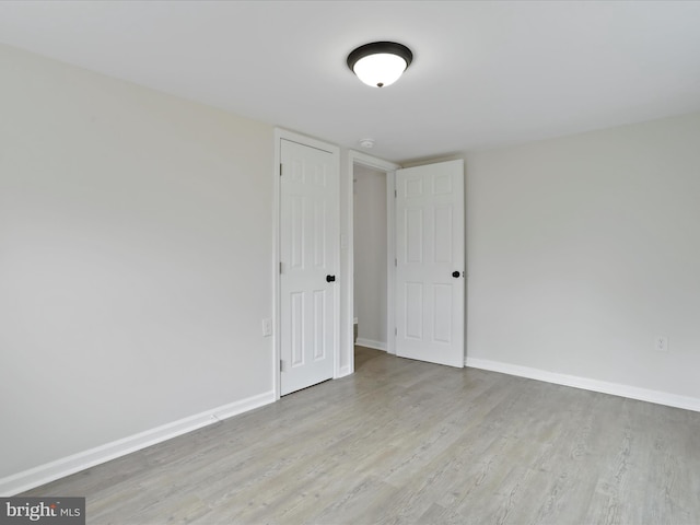 spare room featuring light wood finished floors and baseboards