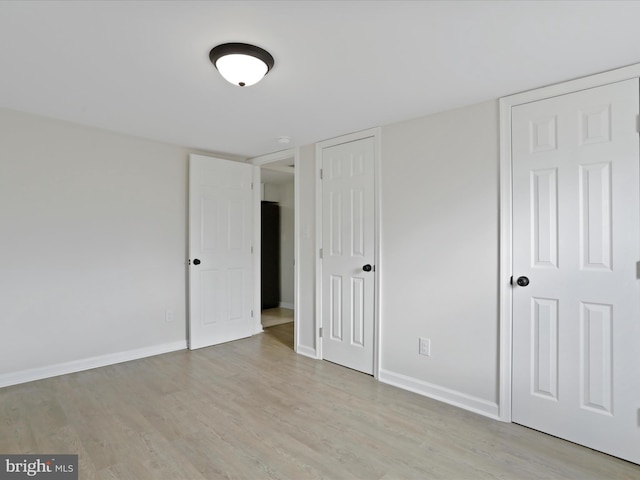 unfurnished bedroom featuring light wood-type flooring and baseboards