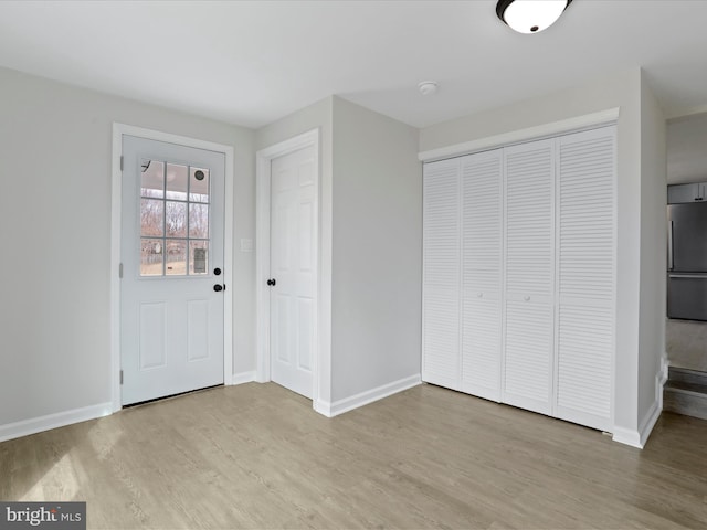 foyer featuring baseboards and light wood finished floors