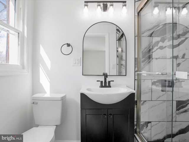 full bathroom with toilet, a marble finish shower, and vanity