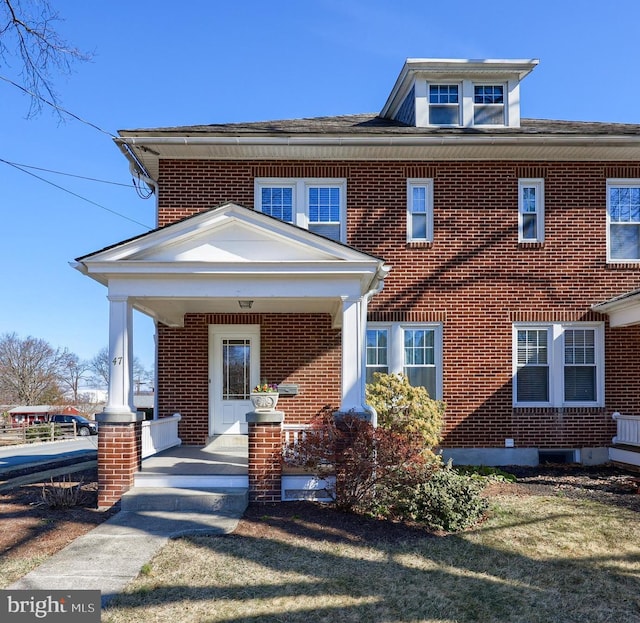 view of front facade featuring a porch and brick siding