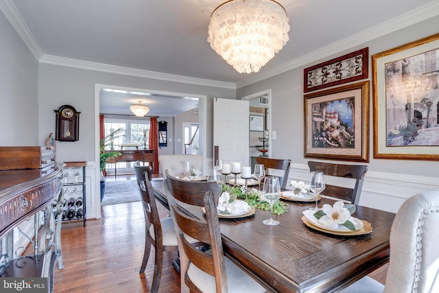 dining room featuring crown molding, a chandelier, and wood finished floors