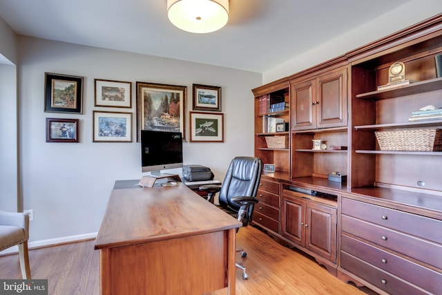 office space with light wood-type flooring and baseboards