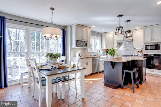 kitchen with a breakfast bar area, stainless steel appliances, recessed lighting, tasteful backsplash, and a kitchen island