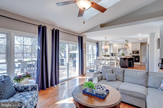 living area with ceiling fan, recessed lighting, visible vents, vaulted ceiling, and light wood-type flooring