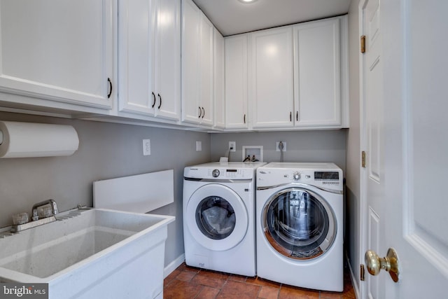 washroom featuring cabinet space, a sink, and separate washer and dryer