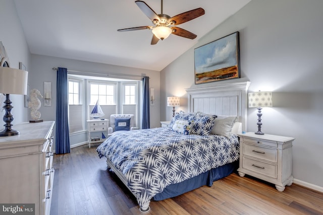 bedroom with lofted ceiling, ceiling fan, wood finished floors, and baseboards