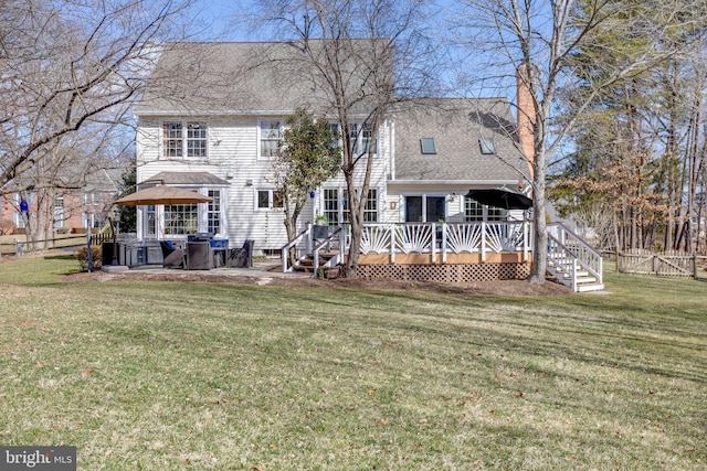 back of house with roof with shingles, a chimney, a lawn, fence, and a wooden deck