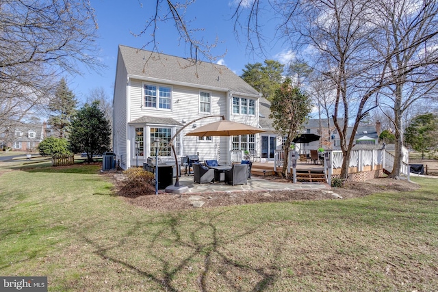 rear view of property featuring central AC, a lawn, a wooden deck, and roof with shingles