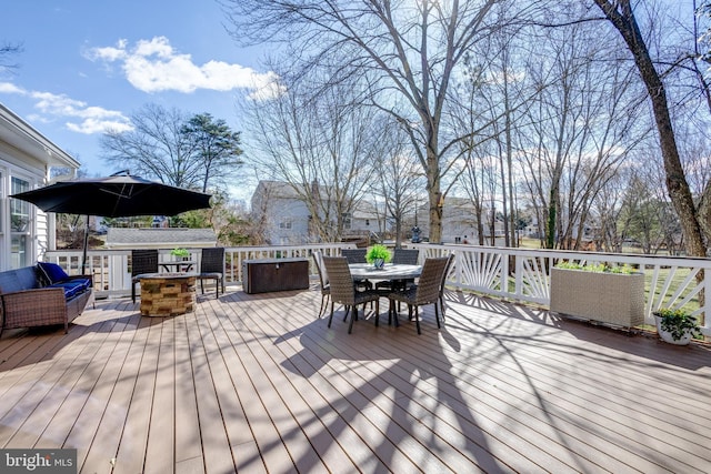 wooden deck with a fire pit and outdoor dining space