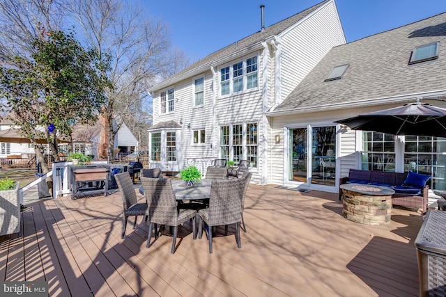 wooden terrace featuring an outdoor fire pit and outdoor dining space