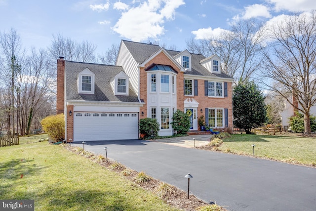 view of front of house featuring aphalt driveway, brick siding, fence, a chimney, and a front yard