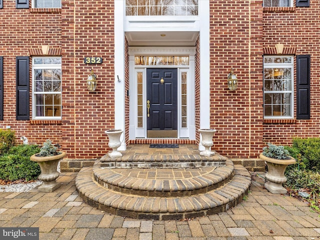 doorway to property with brick siding