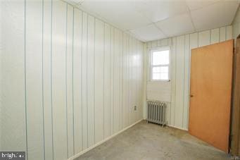 unfurnished room with radiator heating unit