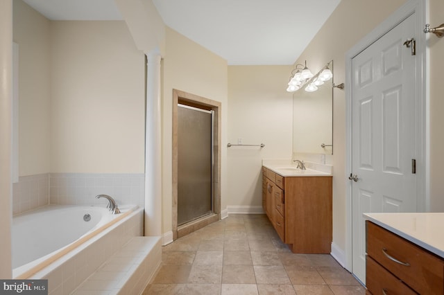 bathroom with vanity, baseboards, a shower stall, a bath, and decorative columns