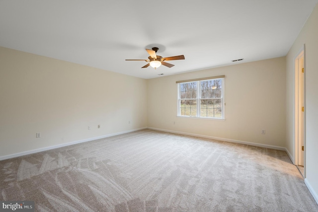 spare room featuring carpet, visible vents, and baseboards