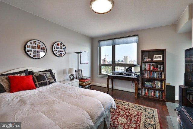 bedroom with dark wood-style flooring and baseboards