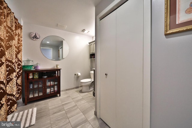 full bath with baseboards, visible vents, and toilet