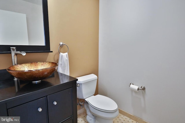 bathroom with baseboards, vanity, and toilet