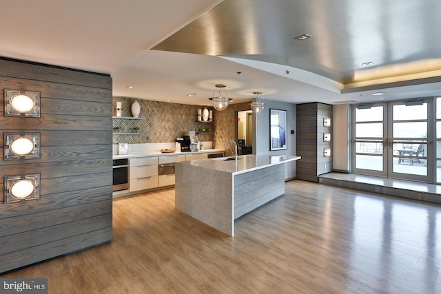 kitchen with open shelves, a spacious island, light countertops, white cabinetry, and modern cabinets