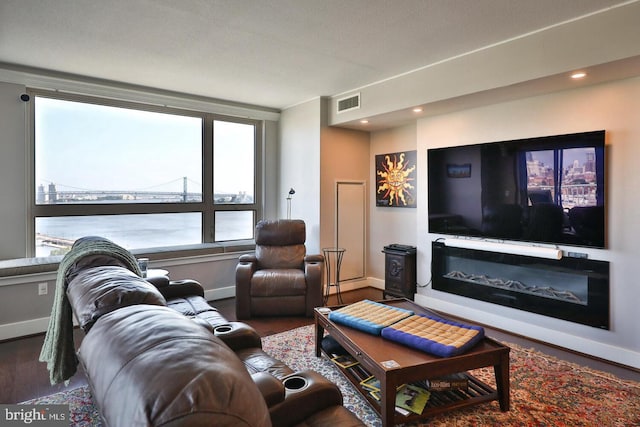 living area with dark wood-style floors, recessed lighting, visible vents, and baseboards