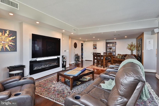 living area featuring recessed lighting, visible vents, wood finished floors, and a glass covered fireplace