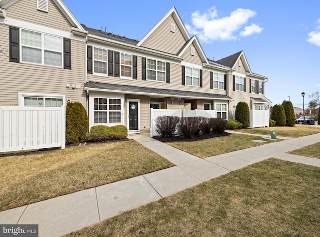 view of property featuring fence and a front lawn