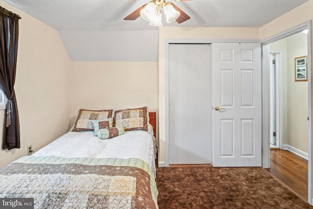 carpeted bedroom with lofted ceiling, ceiling fan, a closet, and baseboards